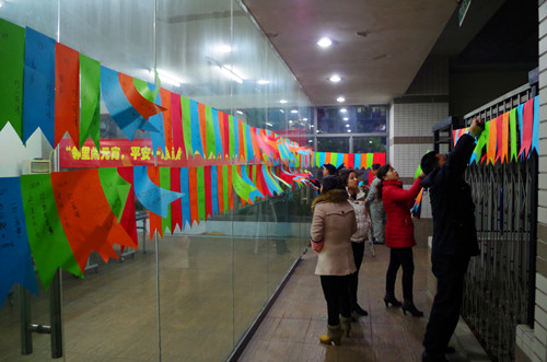 社工和物业管理处人员一起悬挂谜面