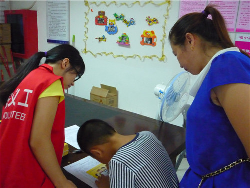 1.义工引导小朋友填写资料.jpg