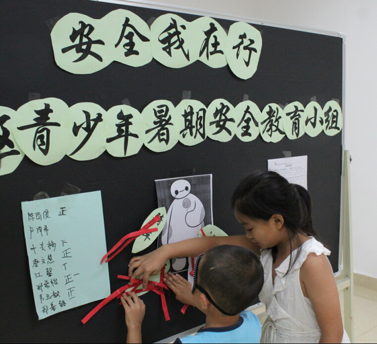 01.小朋友在搭档的指令下张贴暑期安全字条.jpg