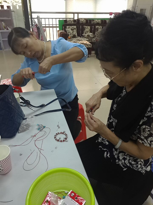 1.阿姨们在做串珠手链.jpg