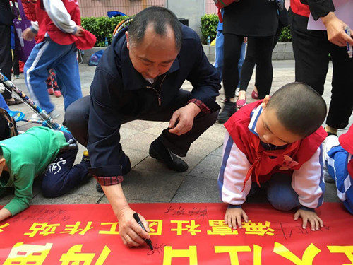02.参与居民在横幅上写下祝福.jpg