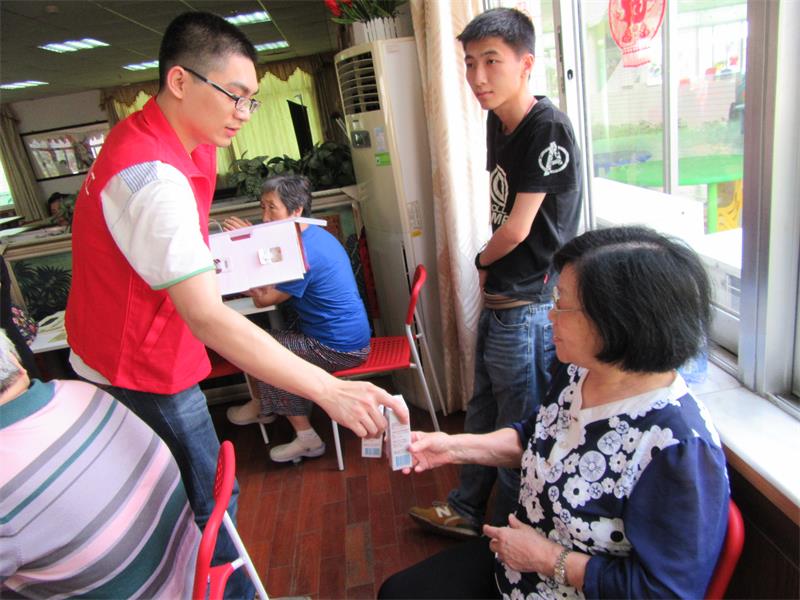 2.义工给老人发牛奶.JPG