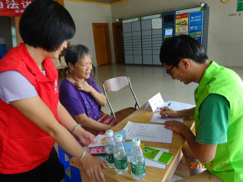 3.社工和义工给等候检查的婆婆做登记.jpg