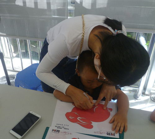 1.一位妈妈正在手把手教孩子剪纸.JPG